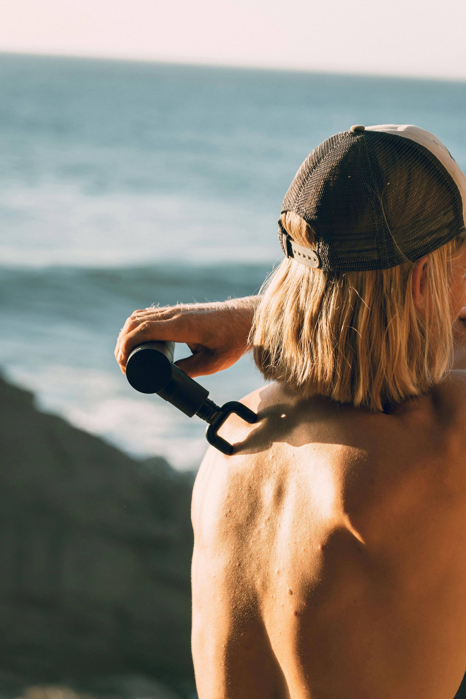 Homme utilisant un pistolet masseur sur le dos